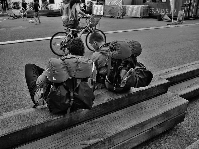 mochileros con mochilas sentados en un banco