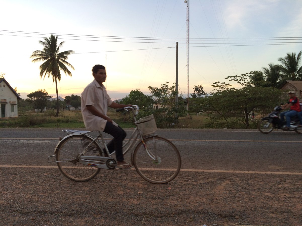Hombre en bicicleta en el campo en Camboya