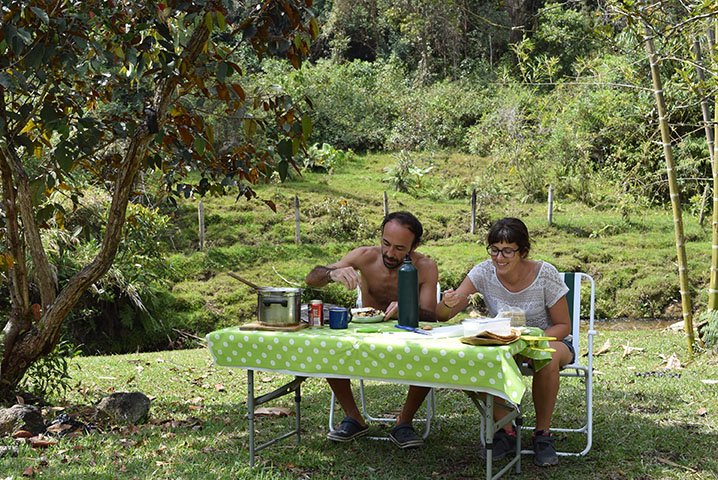 Lidia y Javi de Van Travellers comiendo en el campo en su vuelta al mundo en furgoneta