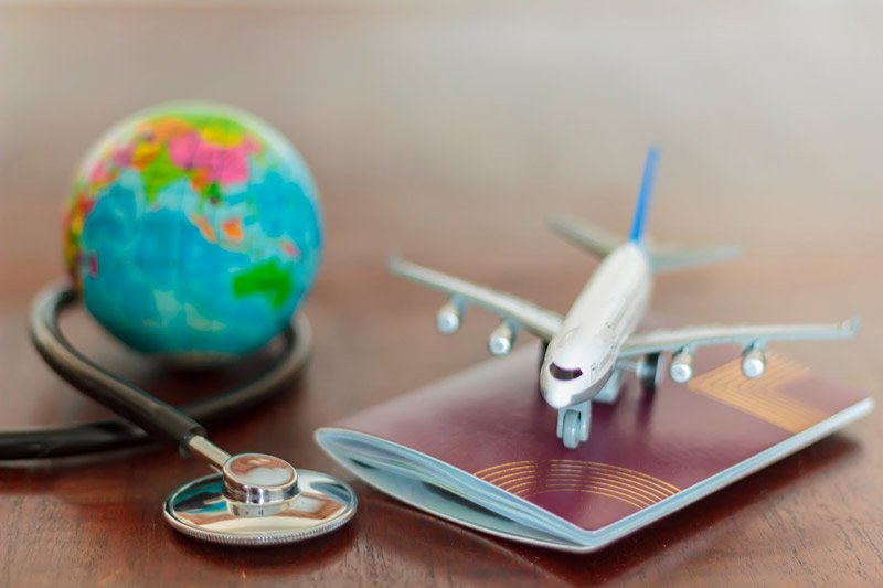 avión, pasaporte, coronavirus sobre una mesa, cómo viajar al extranjero en tiempos de coronavirus