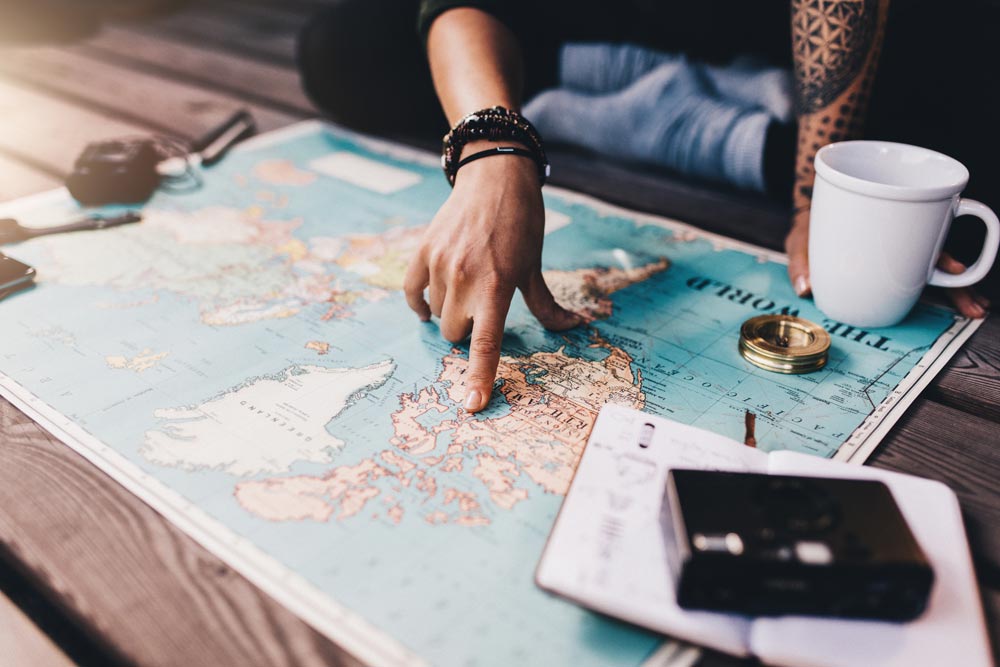 Viajar solo, viajero planeando su viaje con un mapa