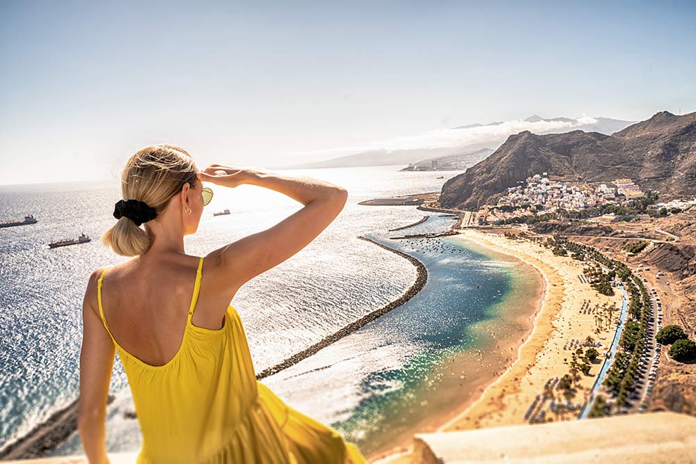 Mujer mirando la playa de Las Teresitas y el pueblo de San Andrés en Tenerife