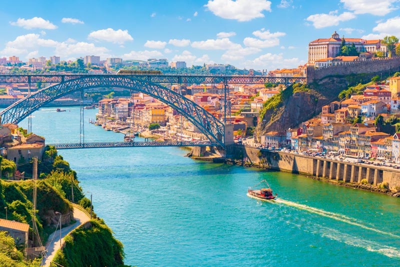 Vista pintoresca y colorida en el casco antiguo de Porto con el puente Ponte Dom Luis sobre el río Douro.