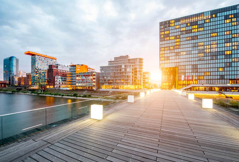 Vista de la puesta del sol en el distrito financiero de Medienhafen con modernos edificios iluminados en la ciudad de Dusseldorf, Alemania