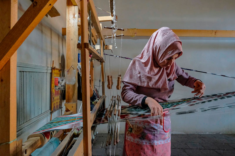 Mujer trabajando en su taller en Margilan, Uzbekistán