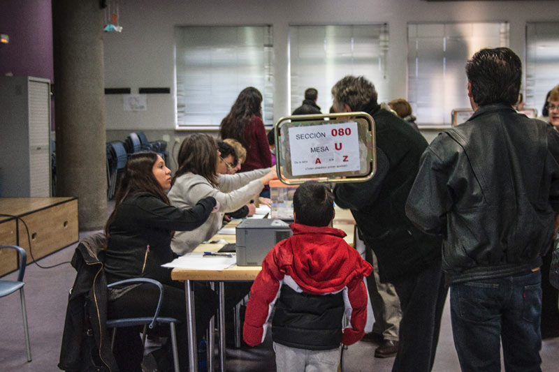 Personas votando en un  colegio electoral